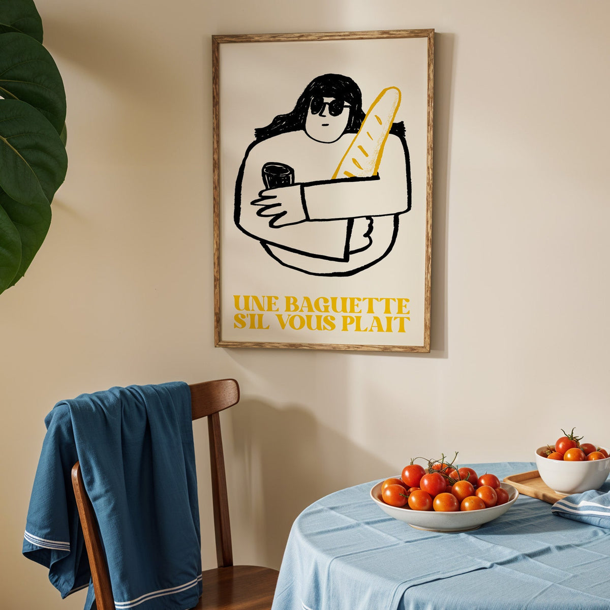 Une baguette french market print in an oak frame above a blue linen table