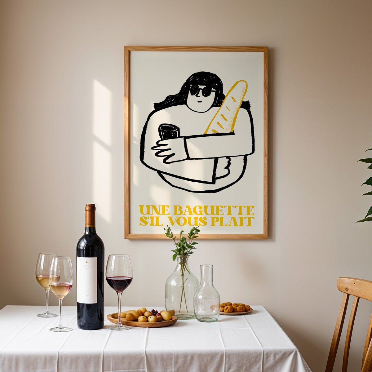 Une baguette french market print in an oak frame above a table laid with red wine