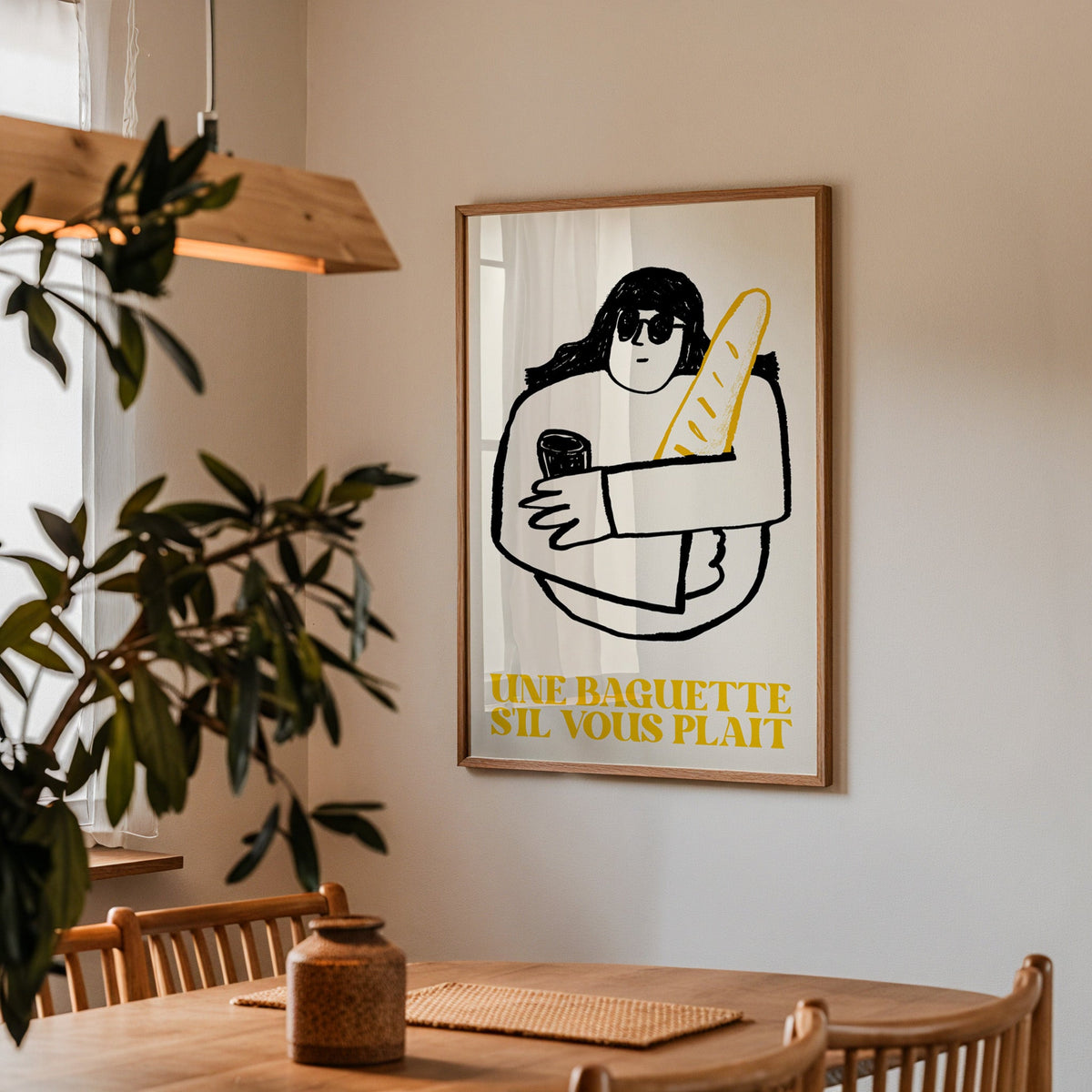 Une baguette french market print in a walnut frame above a table by an olive tree