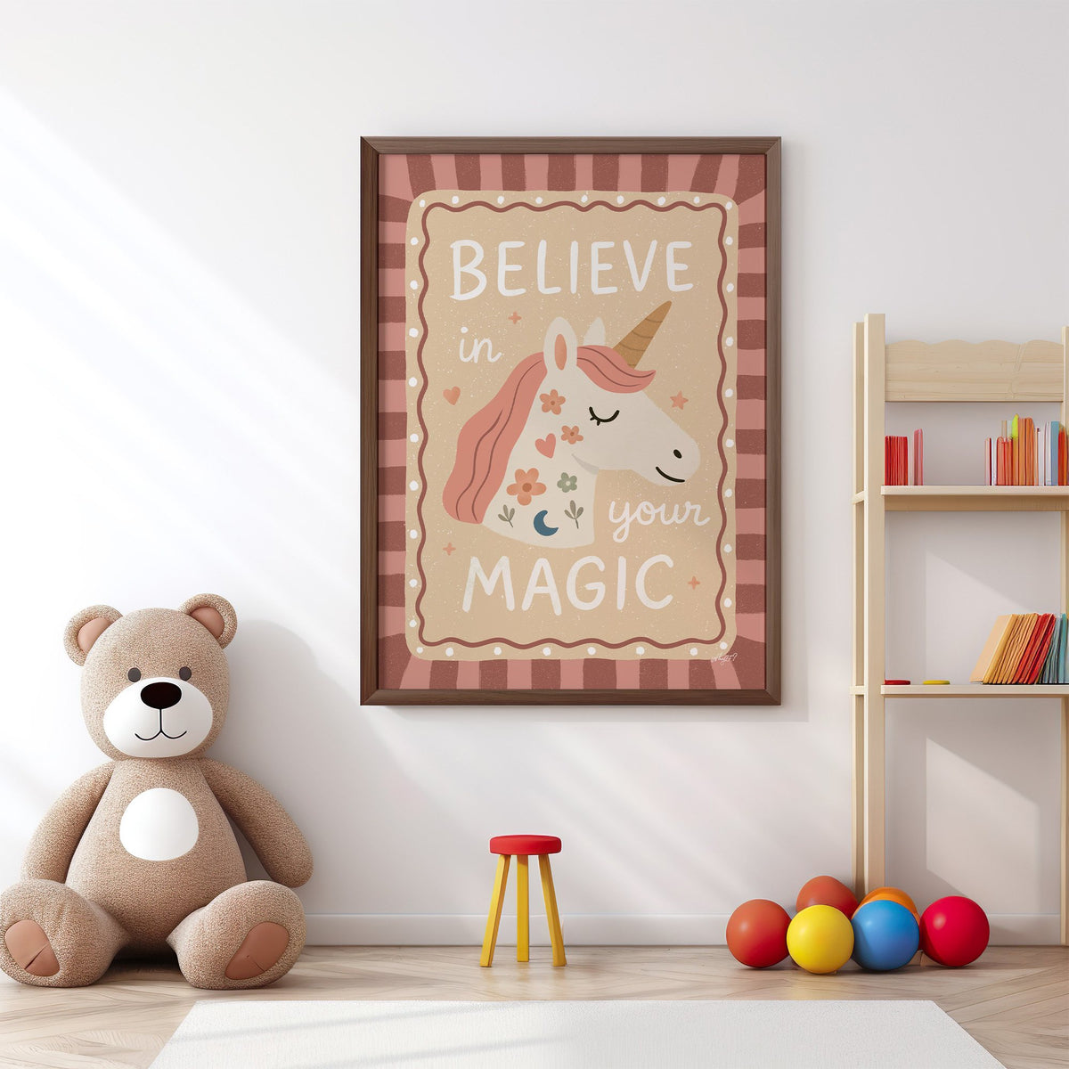 Unicorn head with magic quote nursery print in a walnut frame above a big teddy bear by a bookshelf