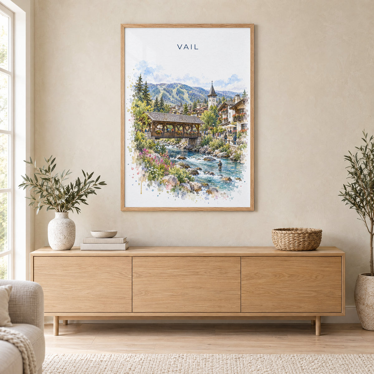 Vail, Colorado watercolor print in an oak frame above a light wood sideboard in a Scandinavian living room
