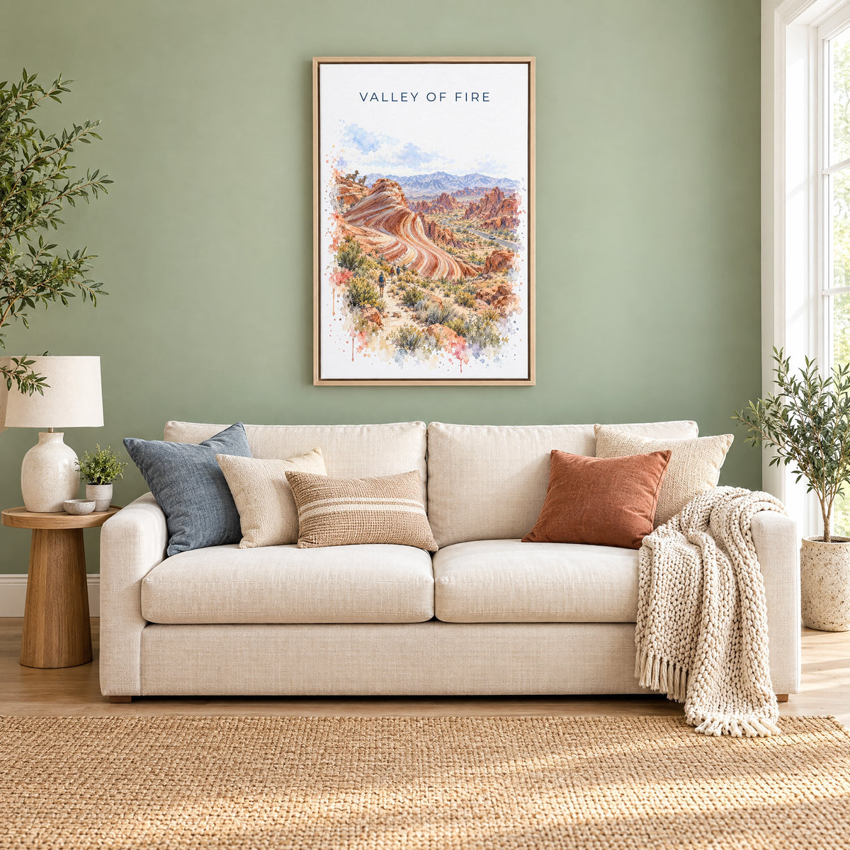 Valley of Fire watercolor print as a natural floater canvas above a cream linen sofa on a sage green wall