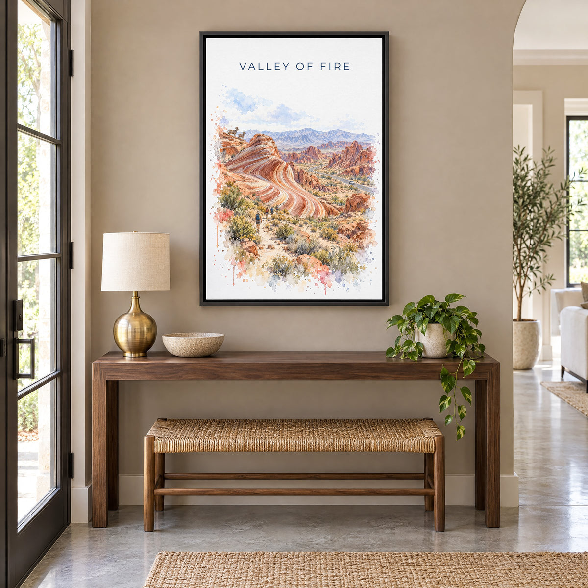 Valley of Fire watercolor print as a black floater canvas above a walnut console and woven bench in an entryway