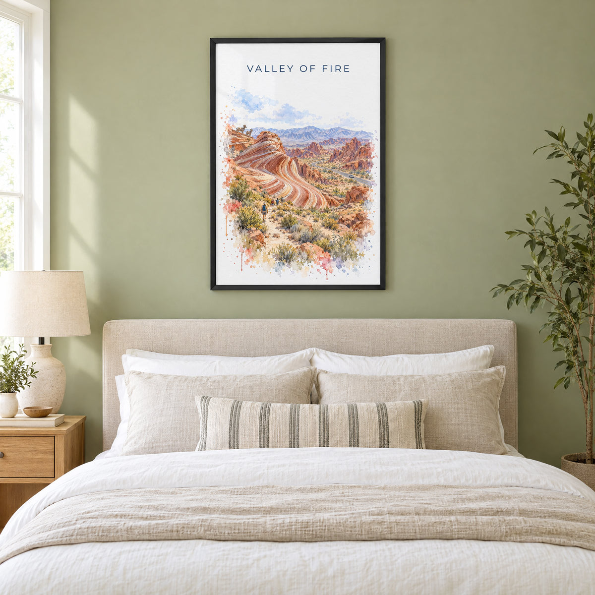 Valley of Fire watercolor print in a black frame above an upholstered headboard in a sage green bedroom