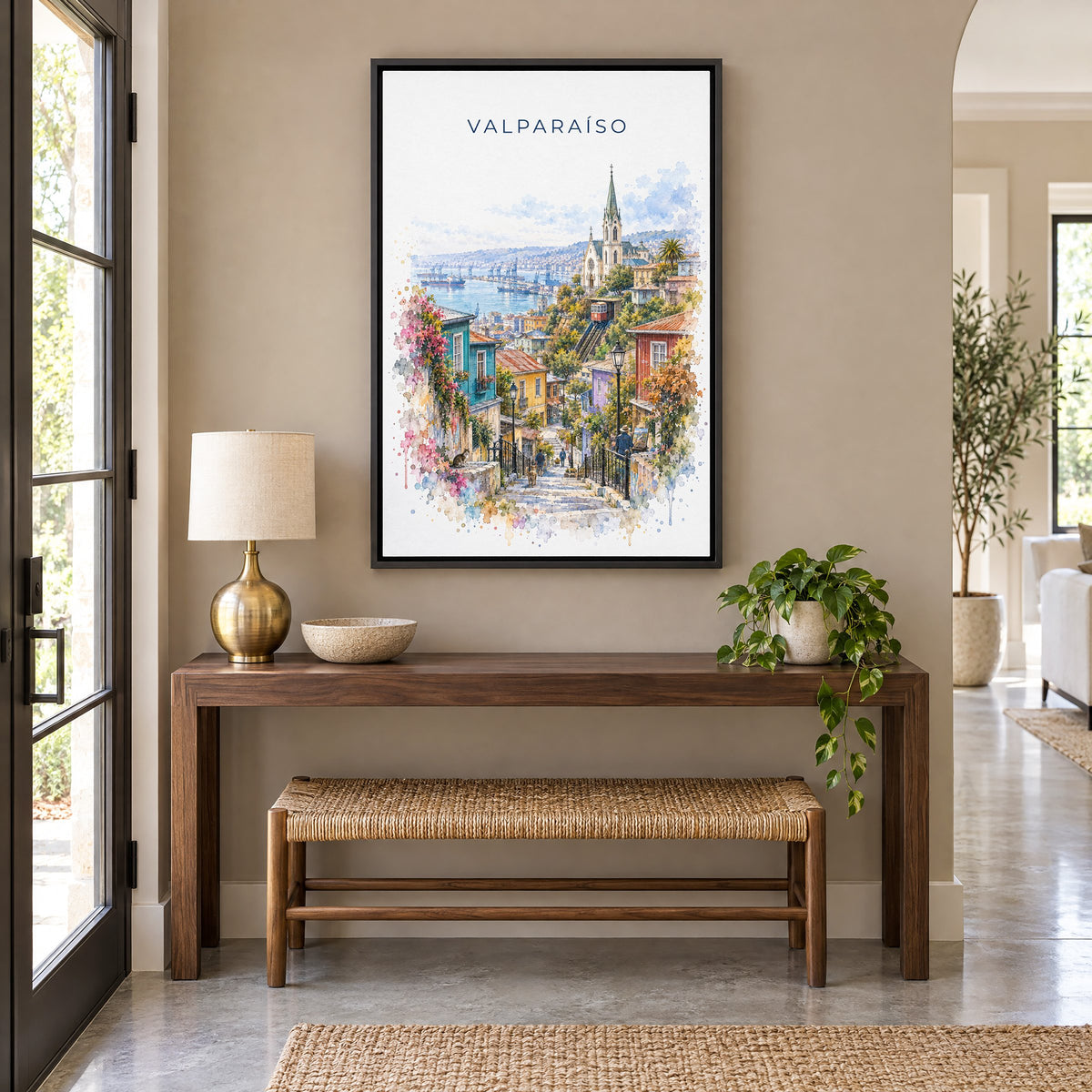 Valparaíso watercolor print as a black floater canvas above a walnut console and woven bench in an entryway