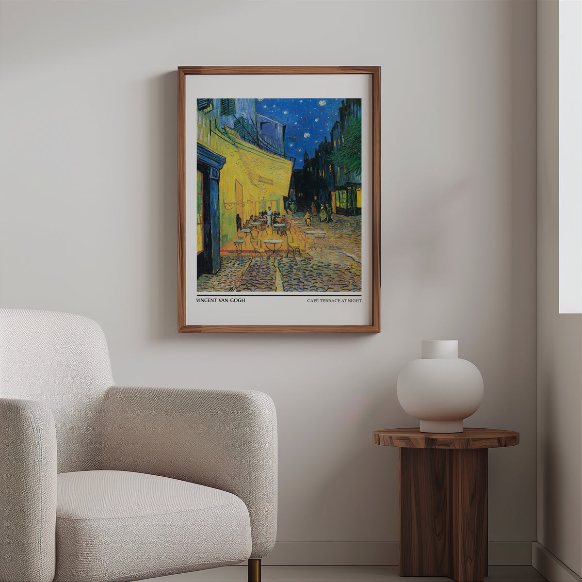Van Gogh café terrace print in a slim walnut frame above a bouclé armchair