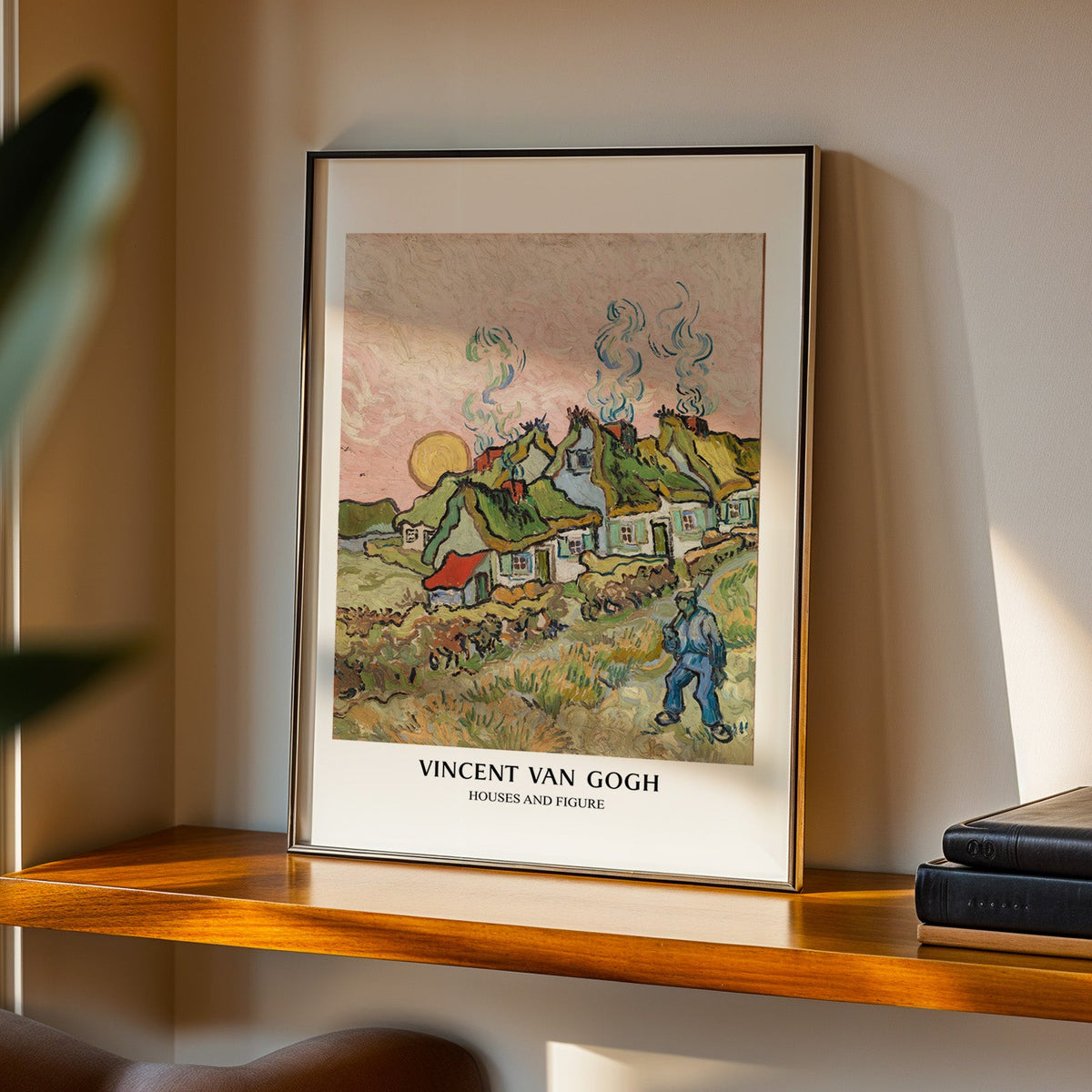 Houses and Figure print in a black frame on a walnut shelf in evening light