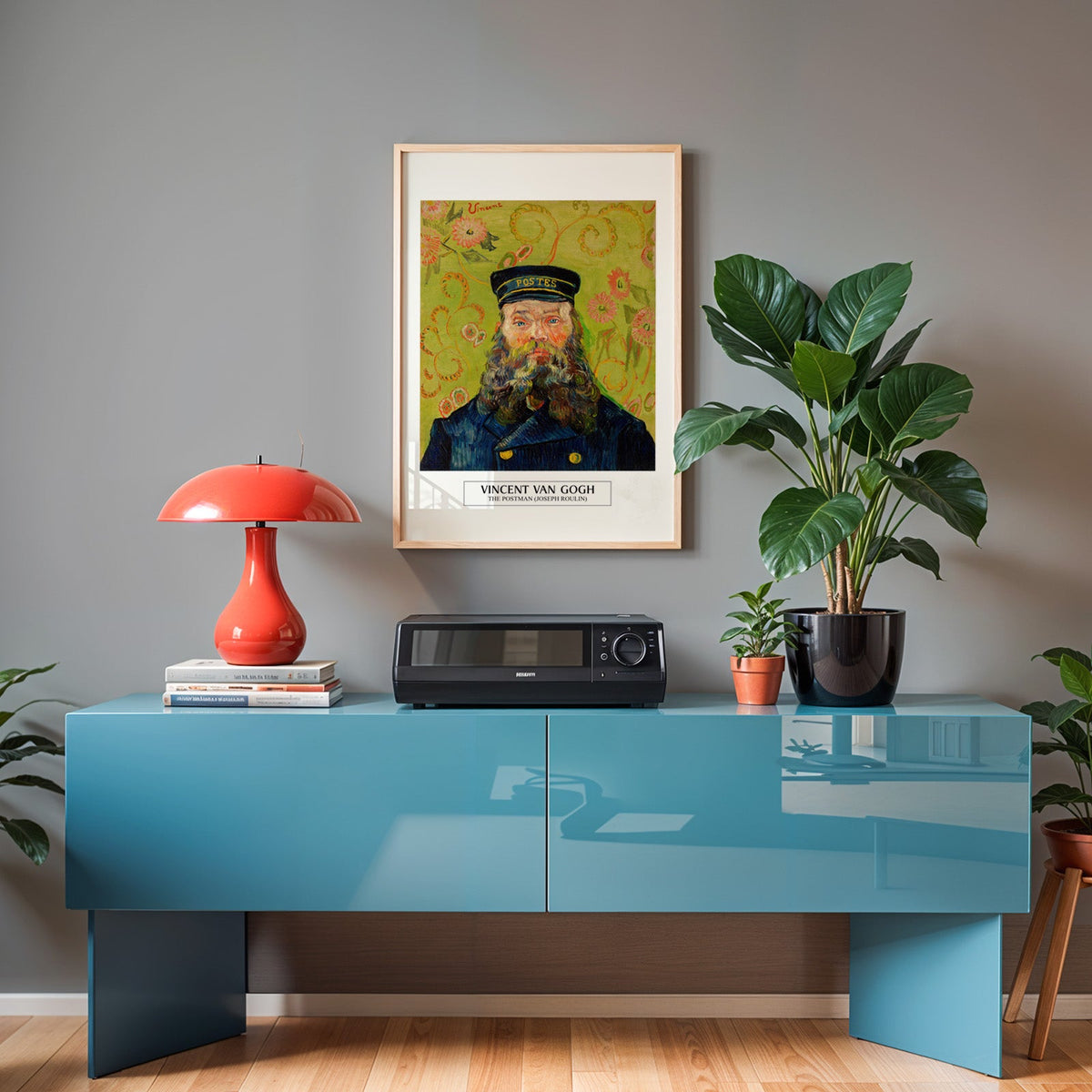 Van Gogh portrait poster in an oak frame above a teal sideboard with a red lamp