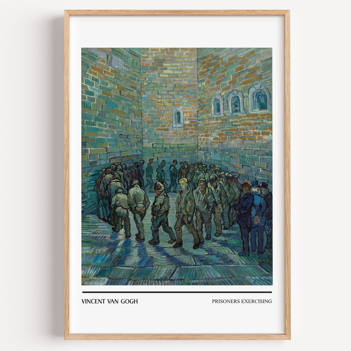 Van Gogh Prisoners Exercising print in a light oak frame on a plain white wall