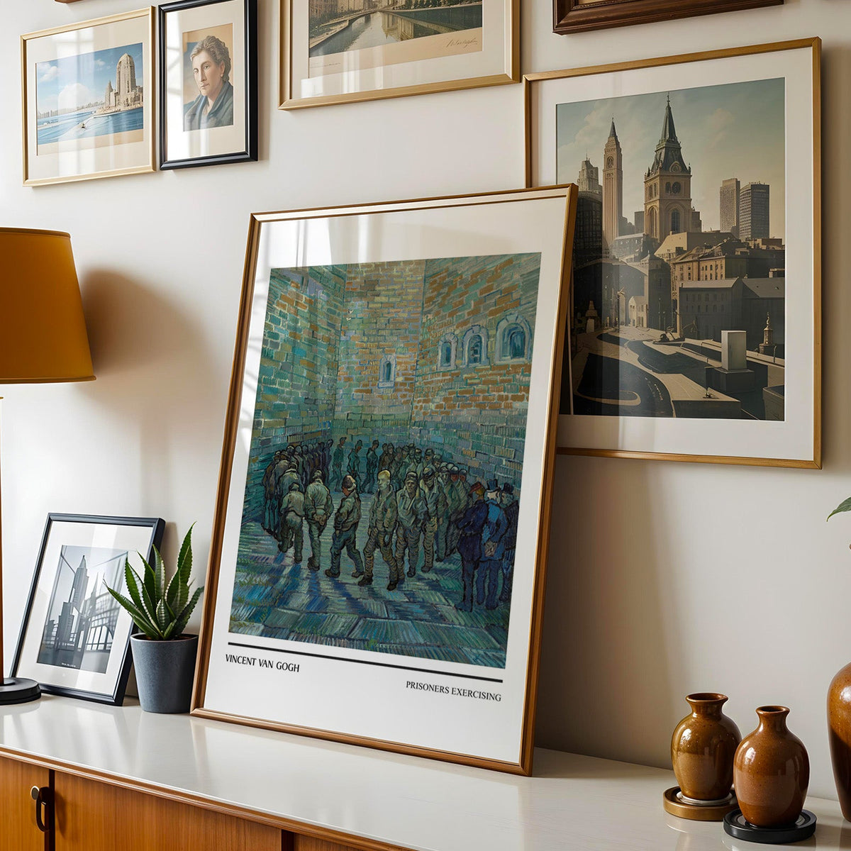Van Gogh print shown in a gold frame leaning on a sideboard in a gallery wall