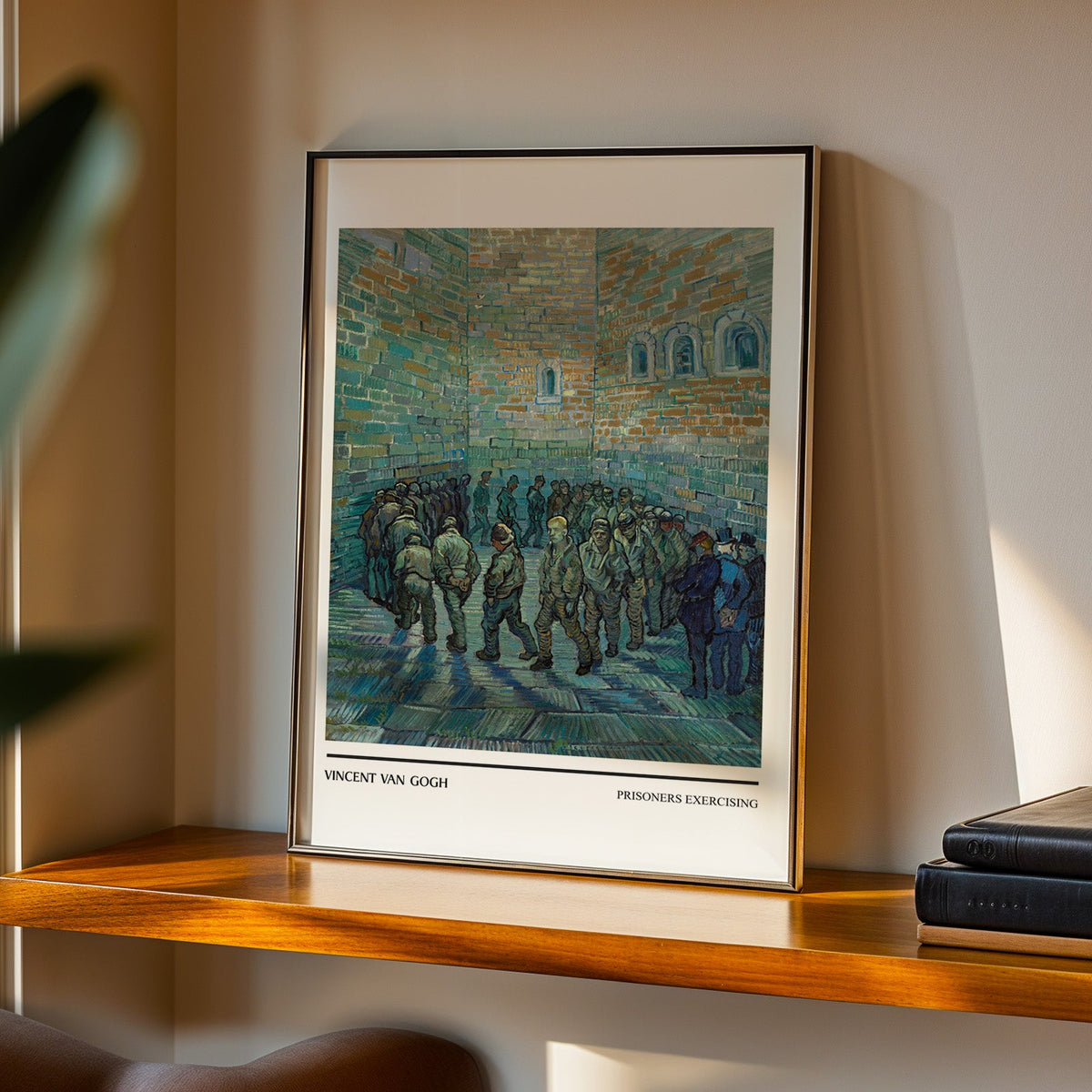 Prisoners Exercising print in a black frame on a walnut shelf in evening light