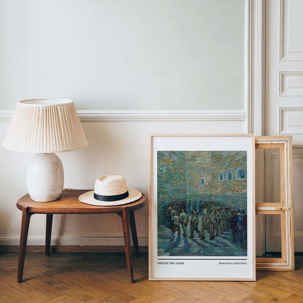 Van Gogh poster in a light wood frame leaning by a bench and panama hat