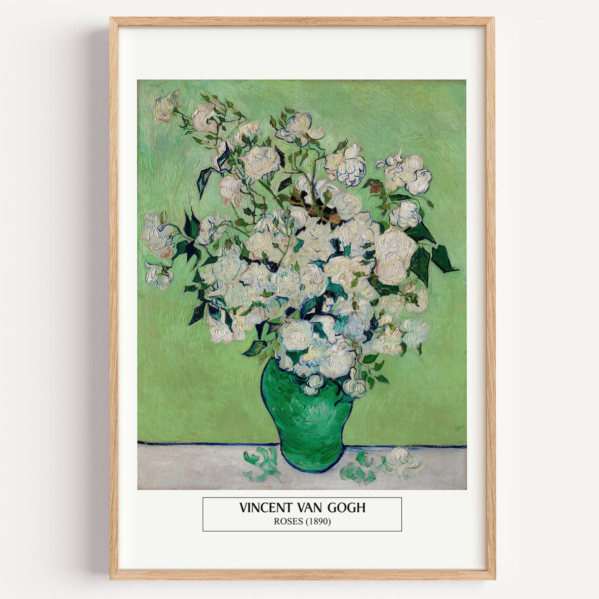 Van Gogh Roses still life print in a light oak frame on a plain white wall
