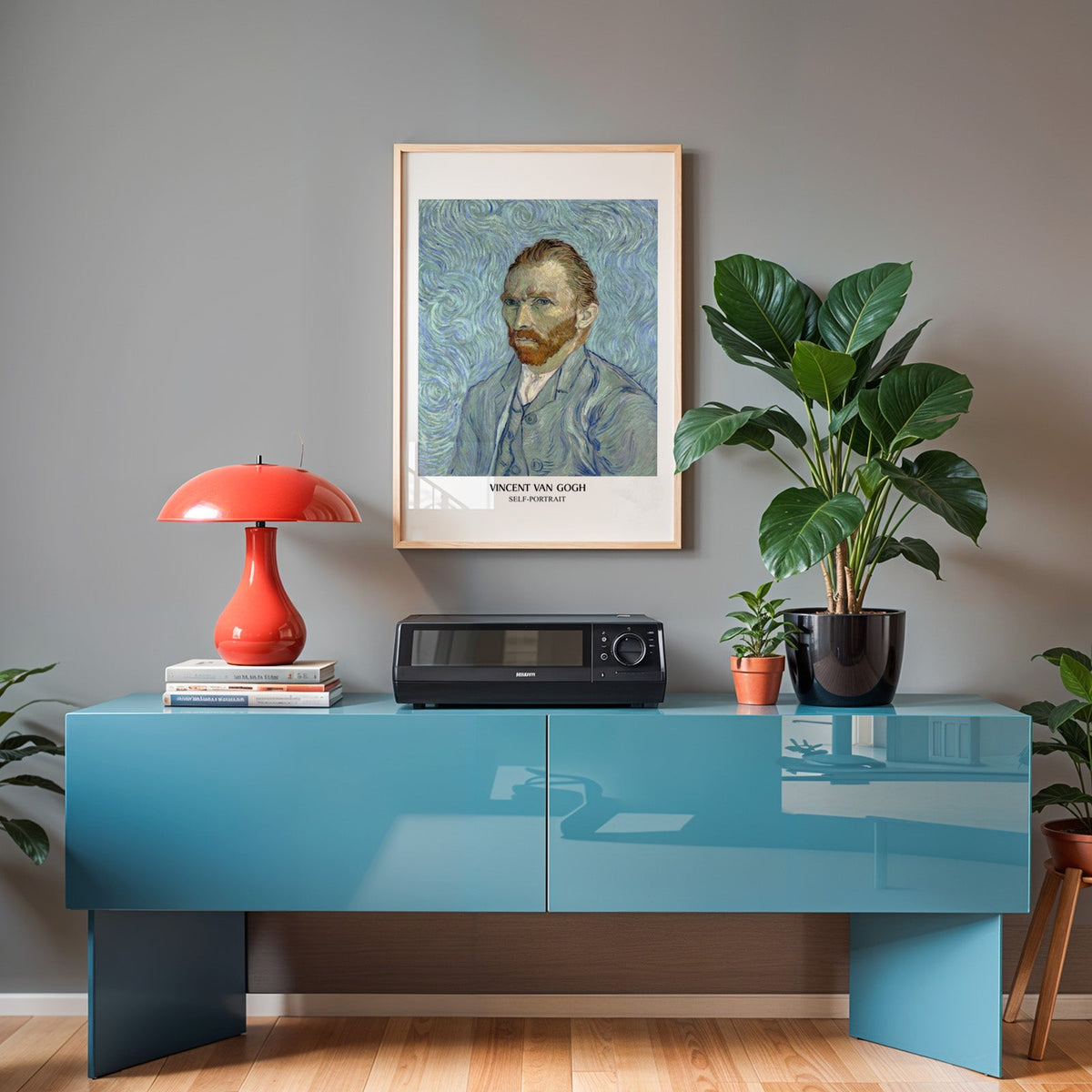Van Gogh portrait poster in an oak frame above a teal sideboard with a red lamp