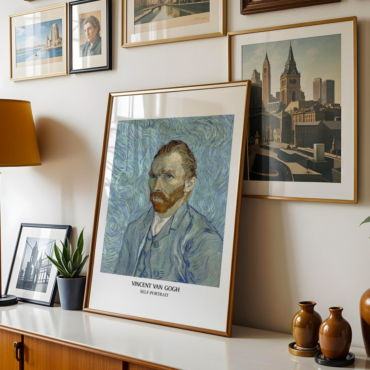 Van Gogh portrait print shown in a gold frame leaning on a sideboard in a gallery wall