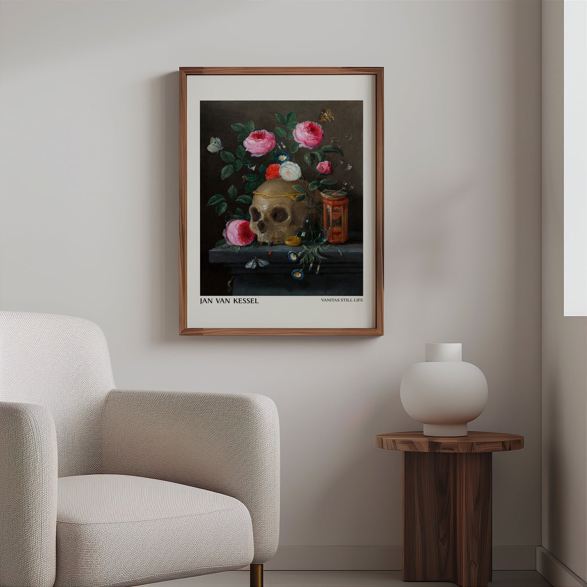 Skull and roses still life print in a slim walnut frame above a bouclé armchair