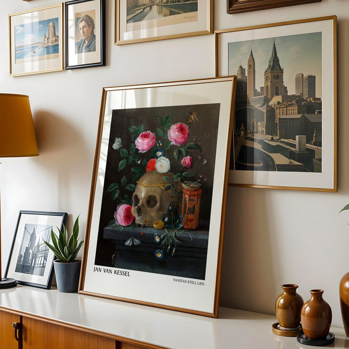 Dutch still life print shown in a gold frame leaning on a sideboard in a gallery wall