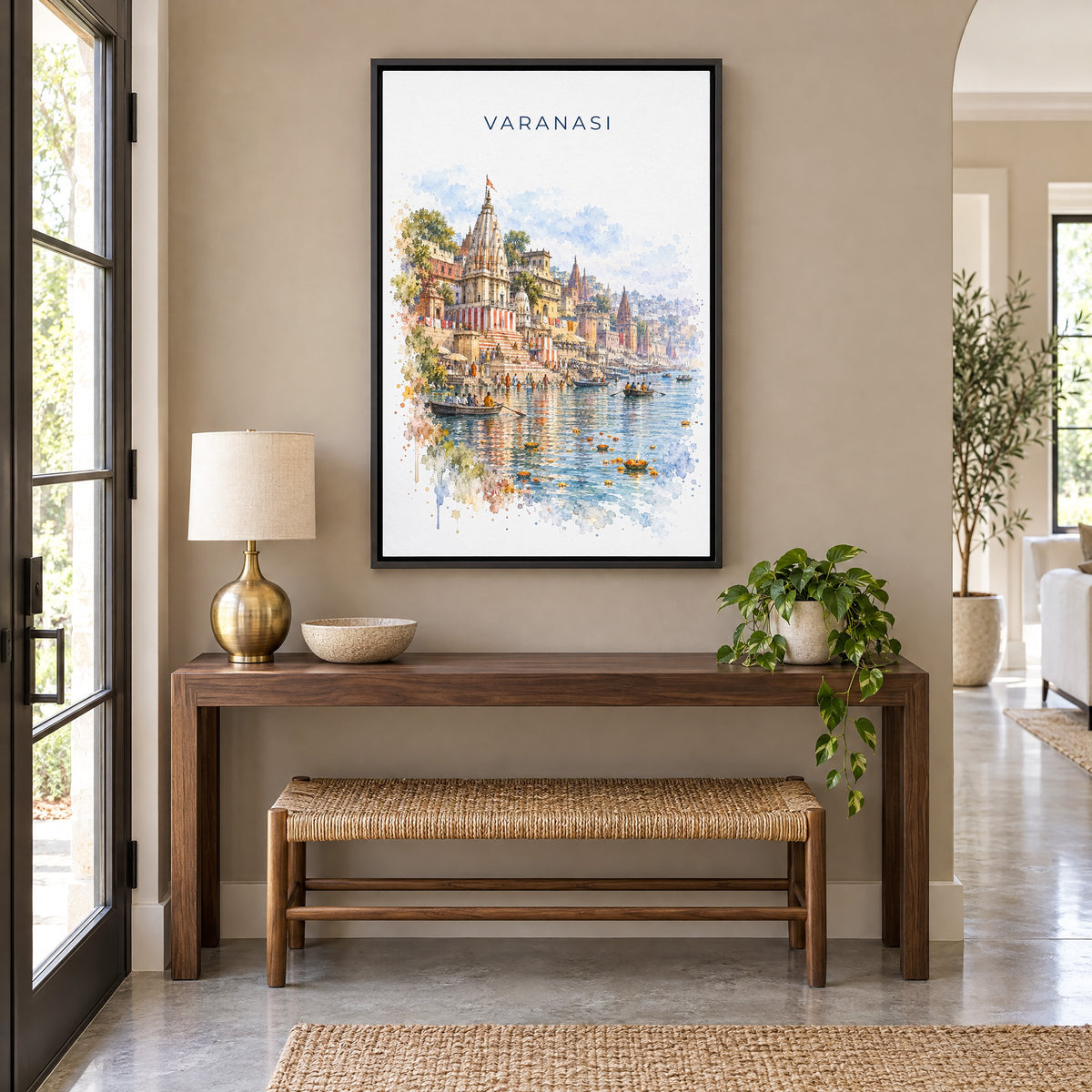 Varanasi watercolor print as a black floater canvas above a walnut console and woven bench in an entryway