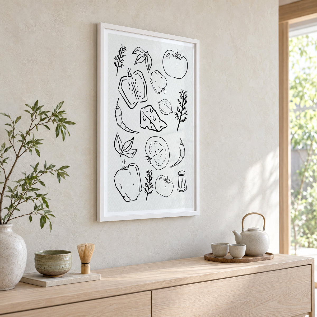 Veggie and cheese sketch on ivory print in a white frame above a pale wood console with a matcha tea set