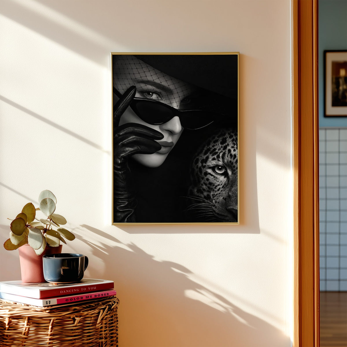 Veiled woman in cat eye glasses with leopard print shown in a gold frame above a wicker basket and stacked books