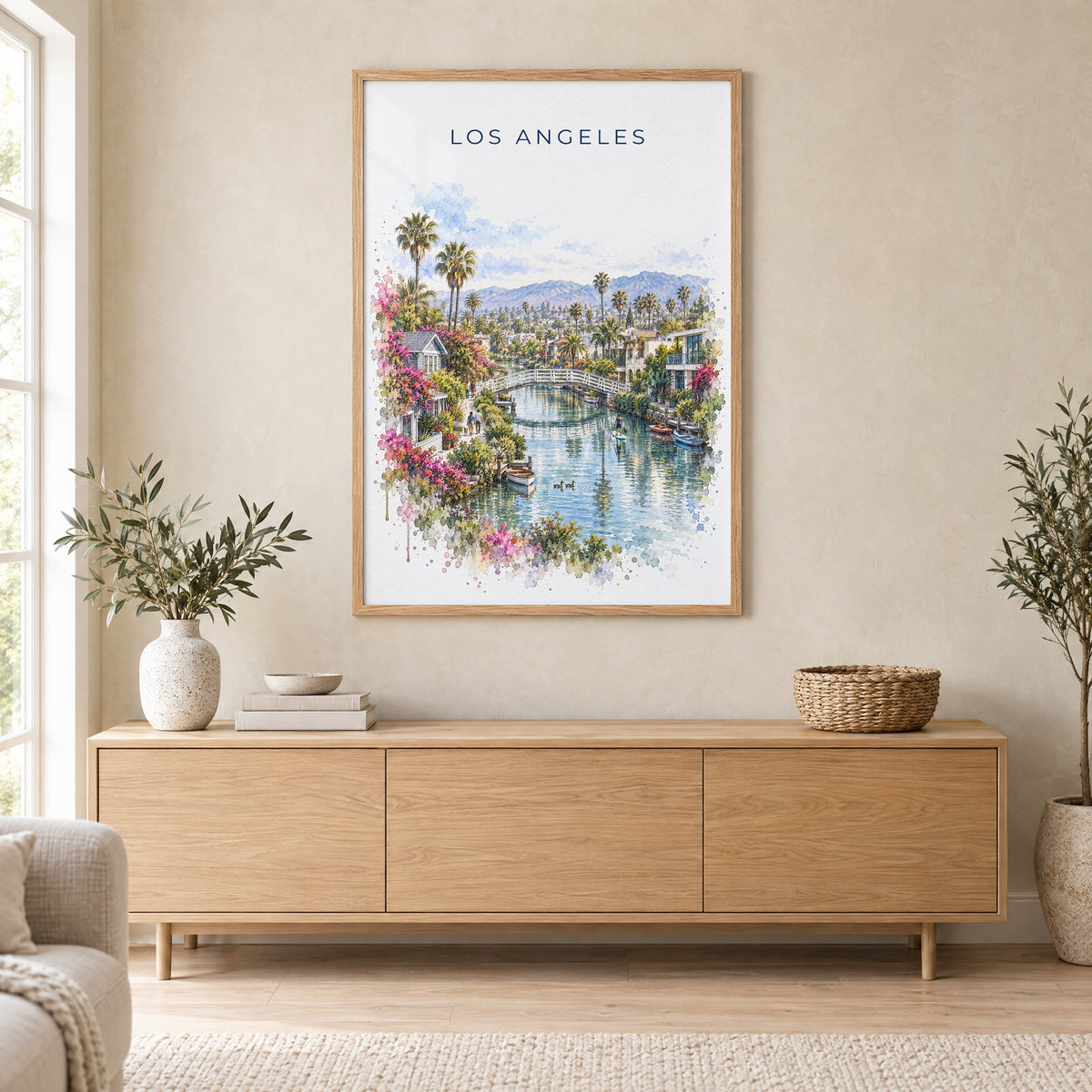 Venice Canals Los Angeles watercolor print in an oak frame above a light wood sideboard in a Scandinavian living room