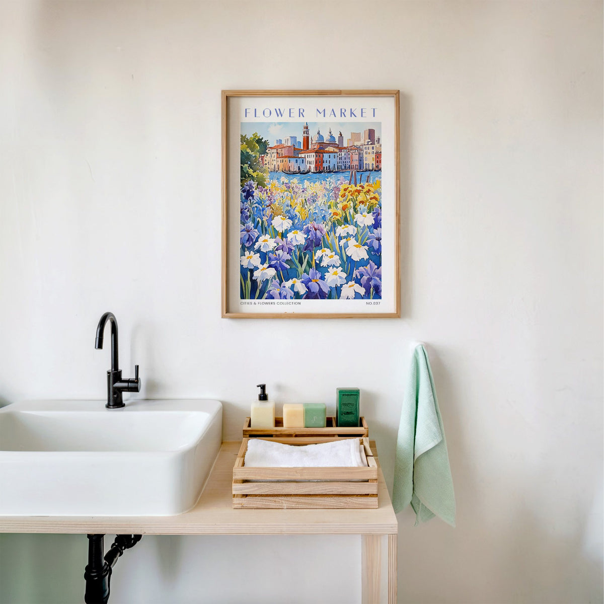 Venice flower market print in an oak frame above a white bathroom sink with folded towels