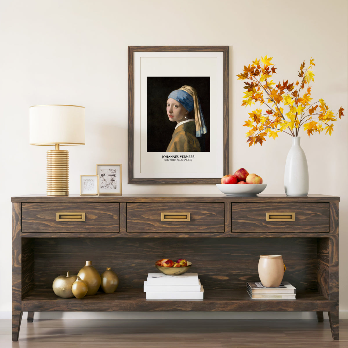 Girl with a Pearl Earring print in a walnut frame above a console with branches