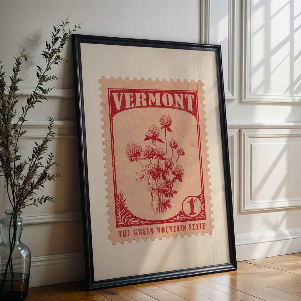 Vermont state flower print in a black frame leaning against a white panelled wall beside olive branches