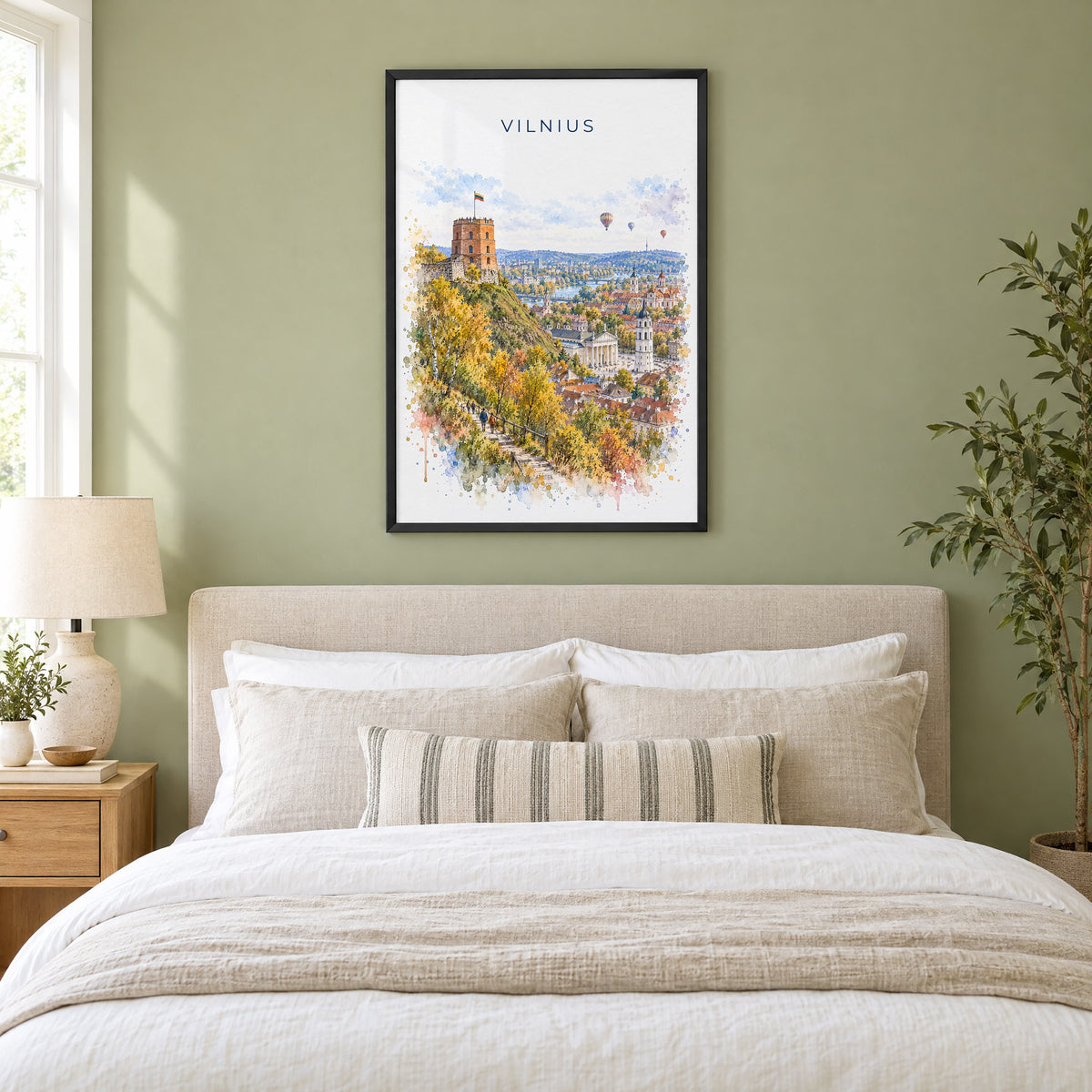 Vilnius watercolor print in a black frame above an upholstered headboard in a sage green bedroom