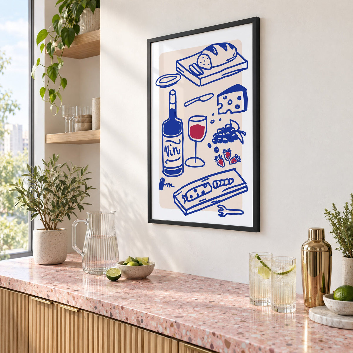 Vin wine and cheese spread print in a black frame above a pink terrazzo cocktail counter with limes, seen at an angle