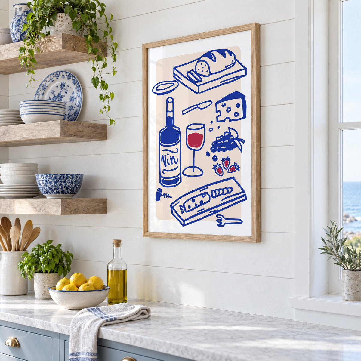 Vin wine and cheese spread print in an oak frame in a white coastal kitchen beside blue and white plates
