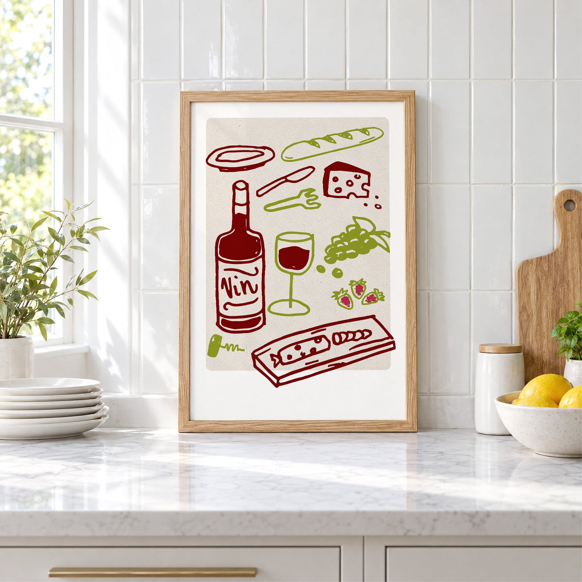 Vin wine picnic doodle print in an oak frame leaning on a marble counter by white tiles and lemons