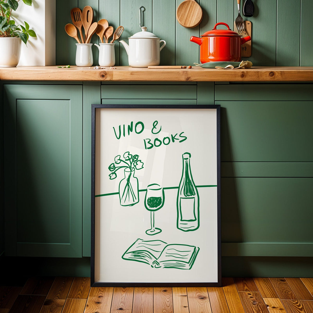 Vino and books green line print in a black frame against sage green cabinets