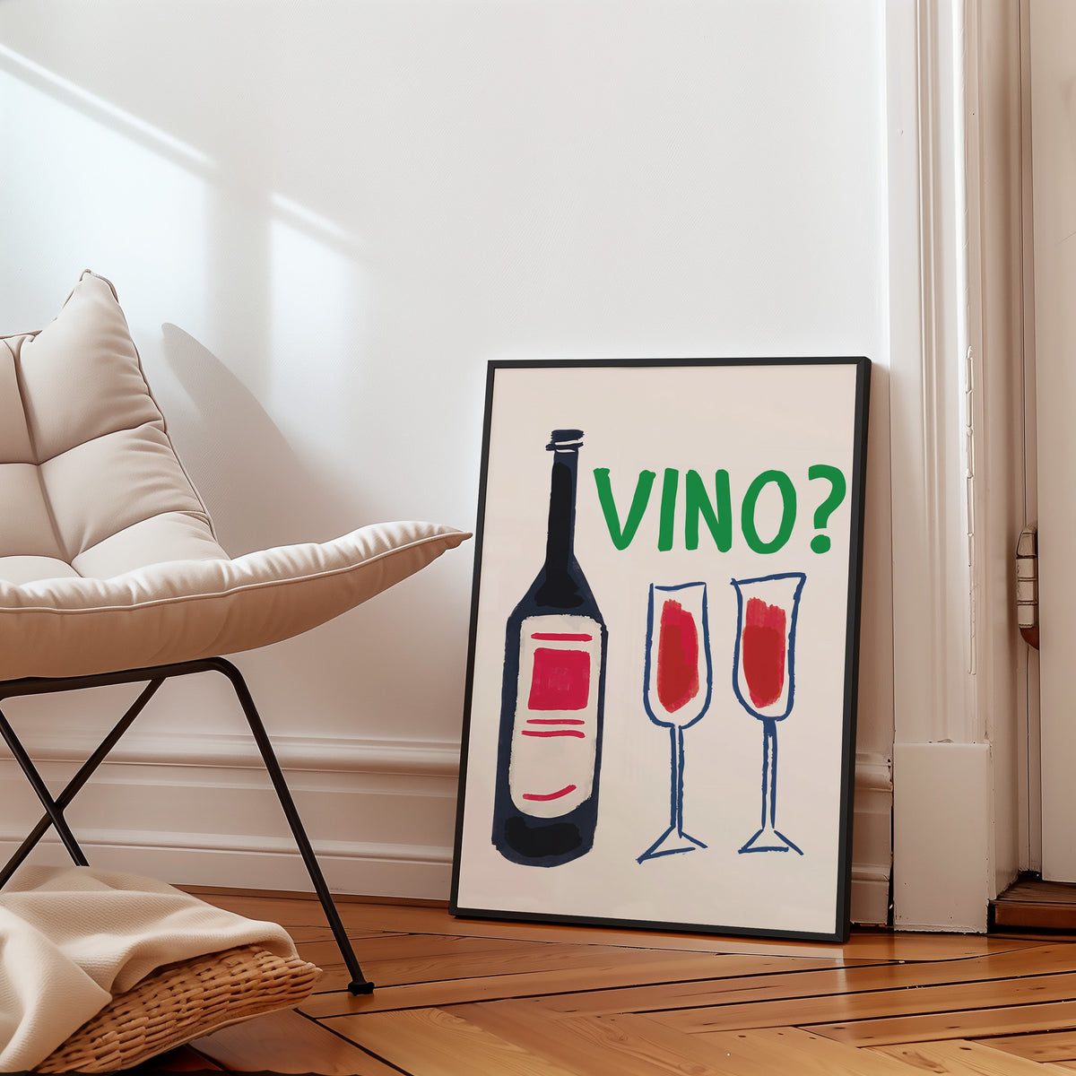 Vino navy bottle and two flutes print in a slim black frame leaning on a herringbone floor beside a cream armchair