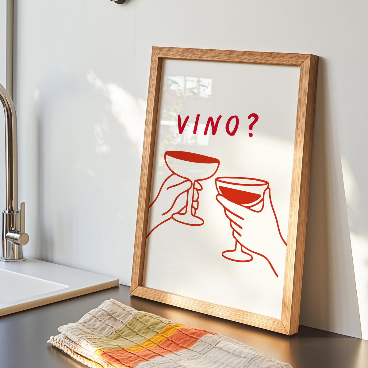 Vino print in an oak frame by the kitchen sink beside a striped tea towel