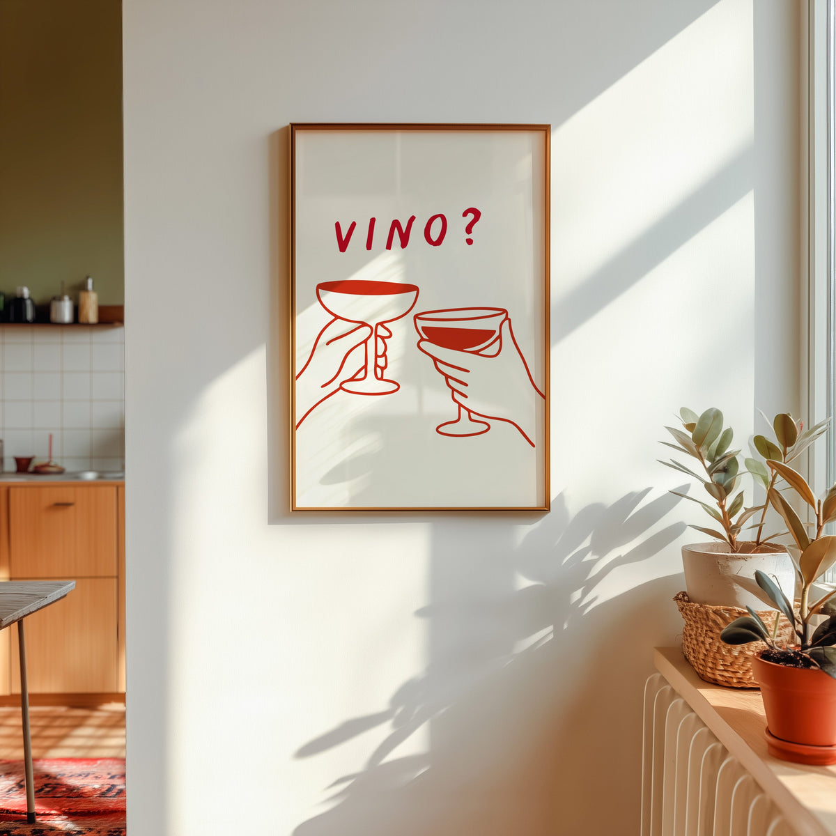 Vino print shown in a gold frame in sunlight with plants and a kitchen beyond