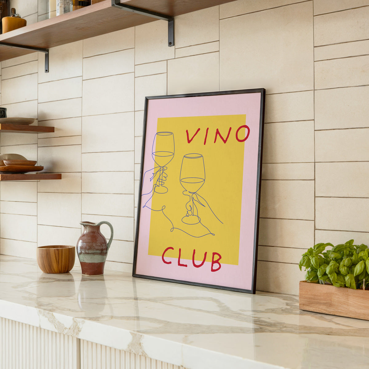 Vino Club print in a black frame leaning on a marble counter in a tiled kitchen