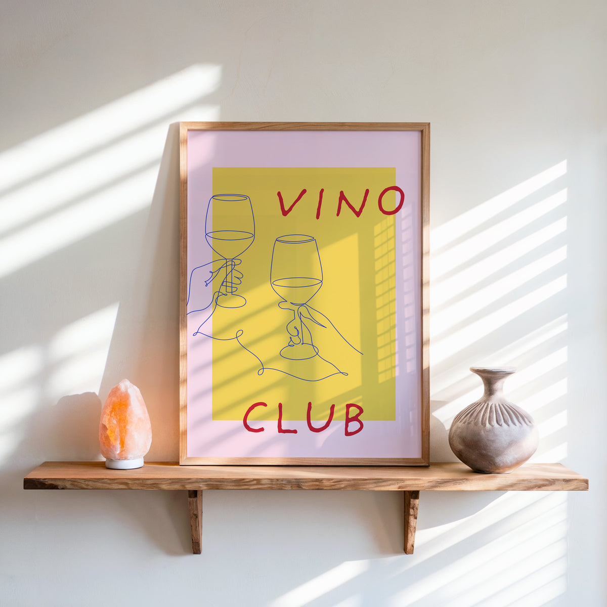 Vino Club print in an oak frame on a live-edge shelf beside a salt lamp