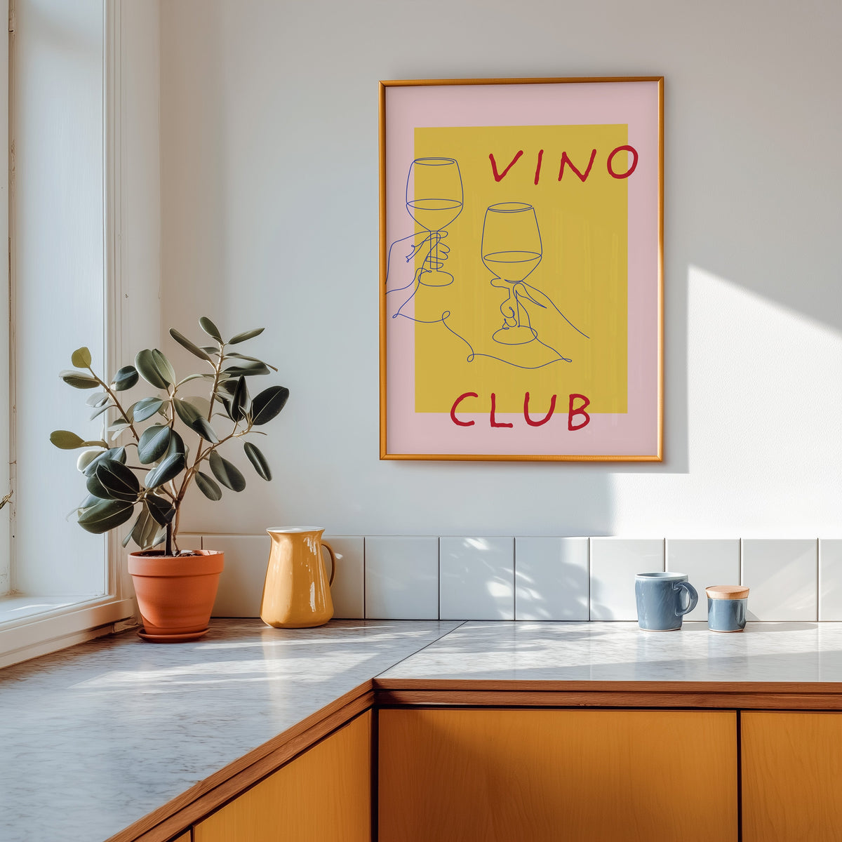 Vino Club print shown in a gold frame above a marble counter in a tan kitchen