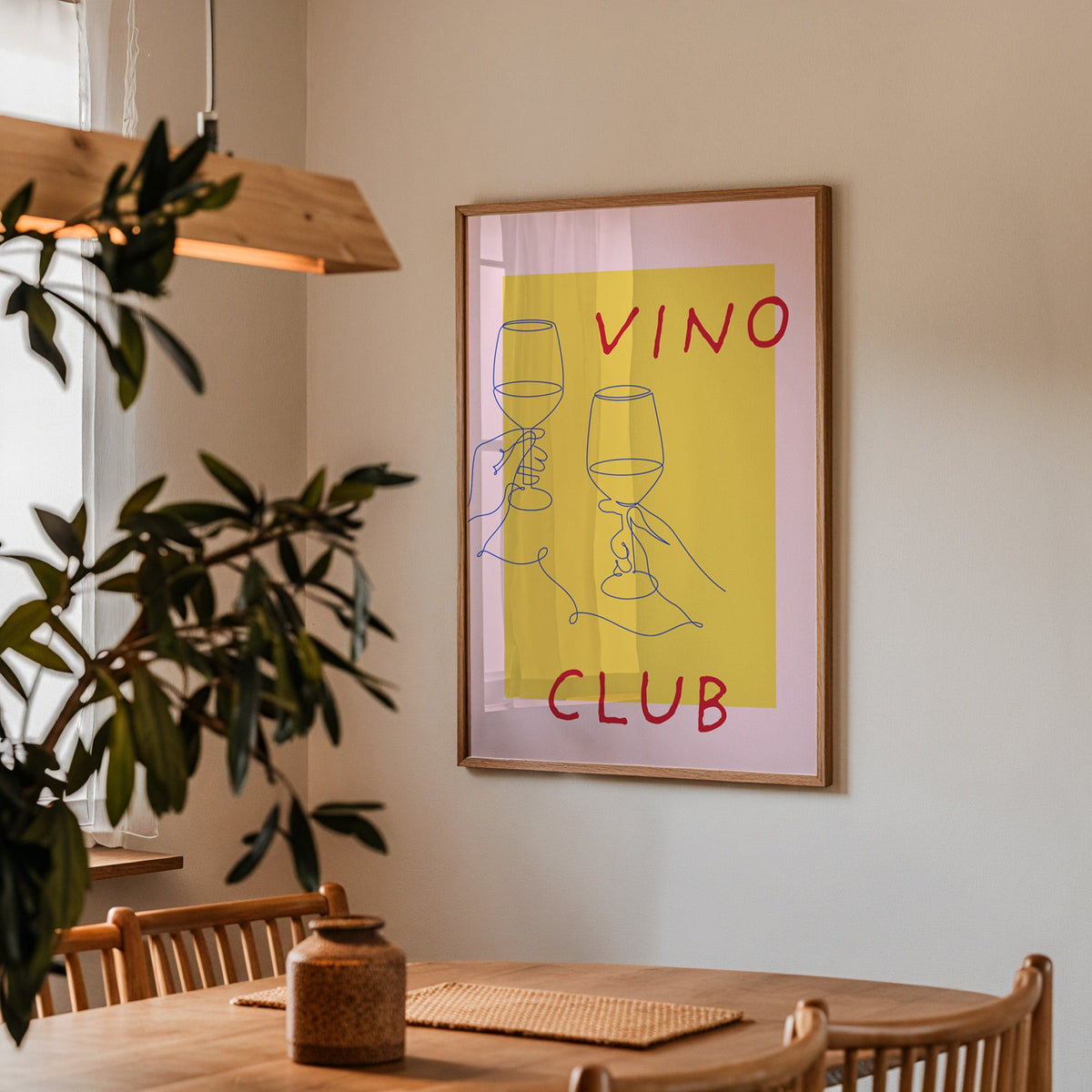 Vino Club print in a walnut frame above a dining table with olive branches