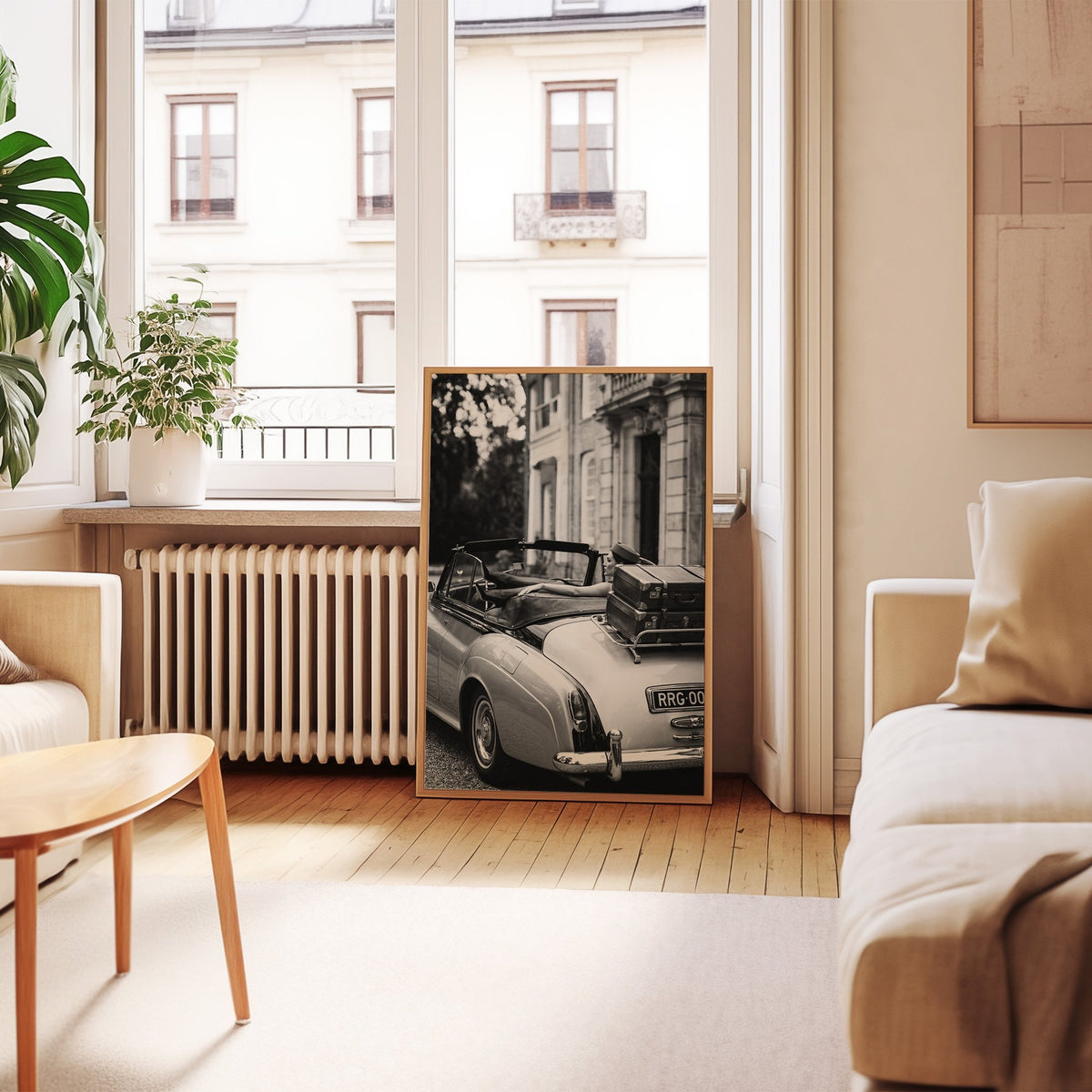 Woman in vintage convertible with leather suitcases print in an oak frame leaning by a French window in a living room