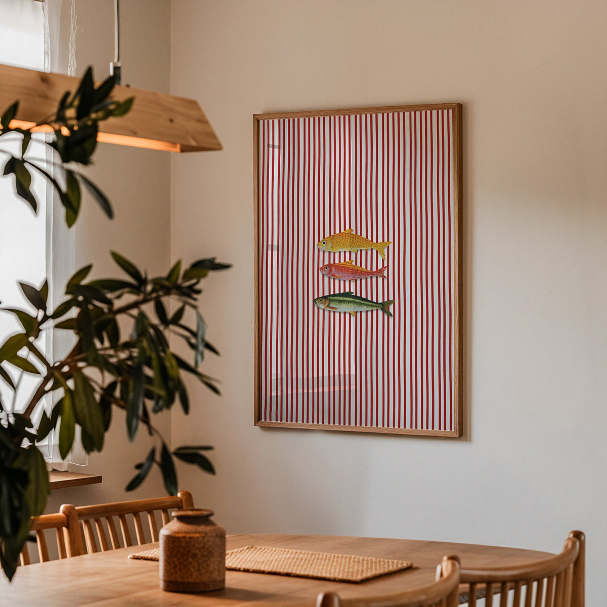 Vintage fish red stripe print in a walnut frame above a table beside an olive tree