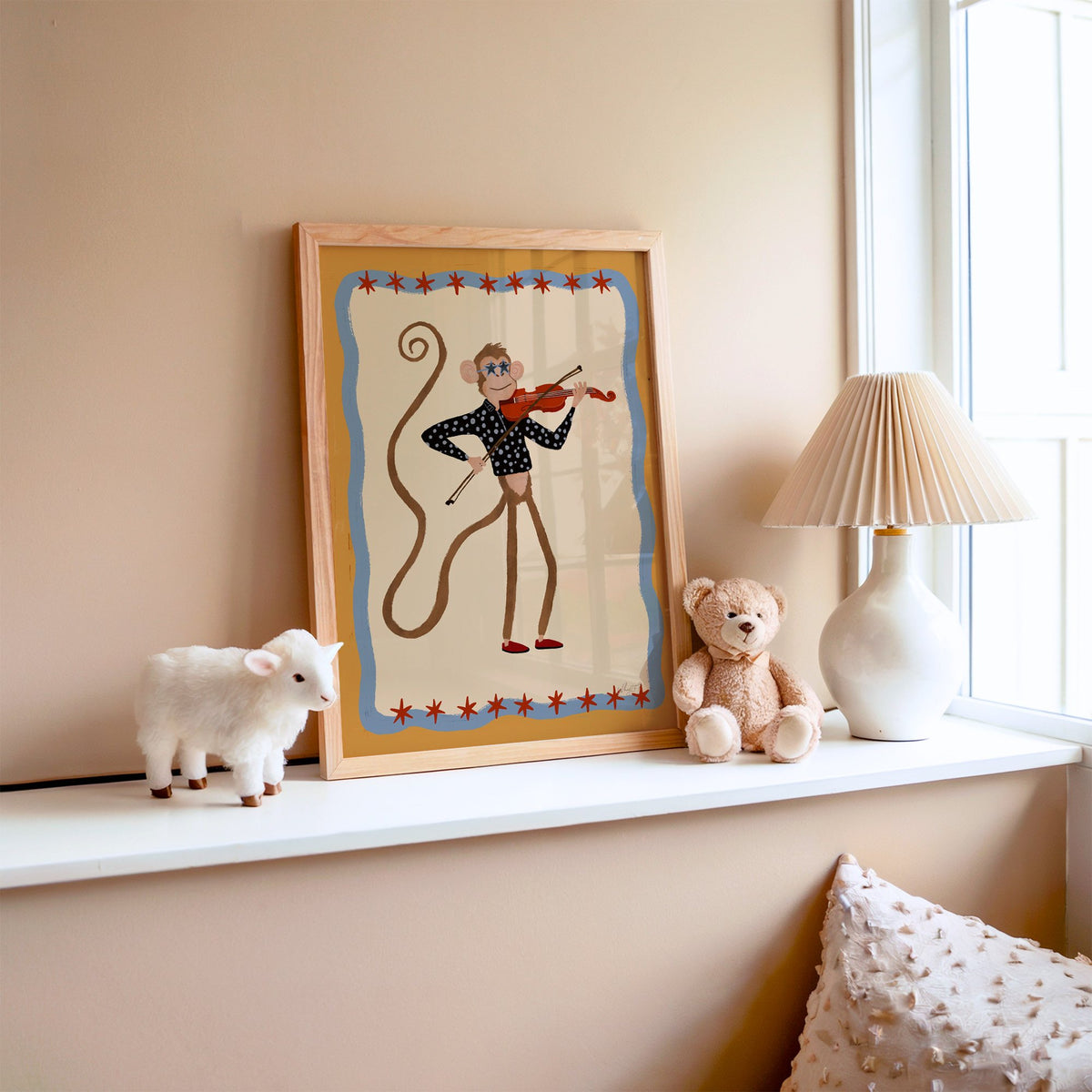 Monkey playing red violin nursery print in an oak frame on a window ledge with a toy lamb and teddy