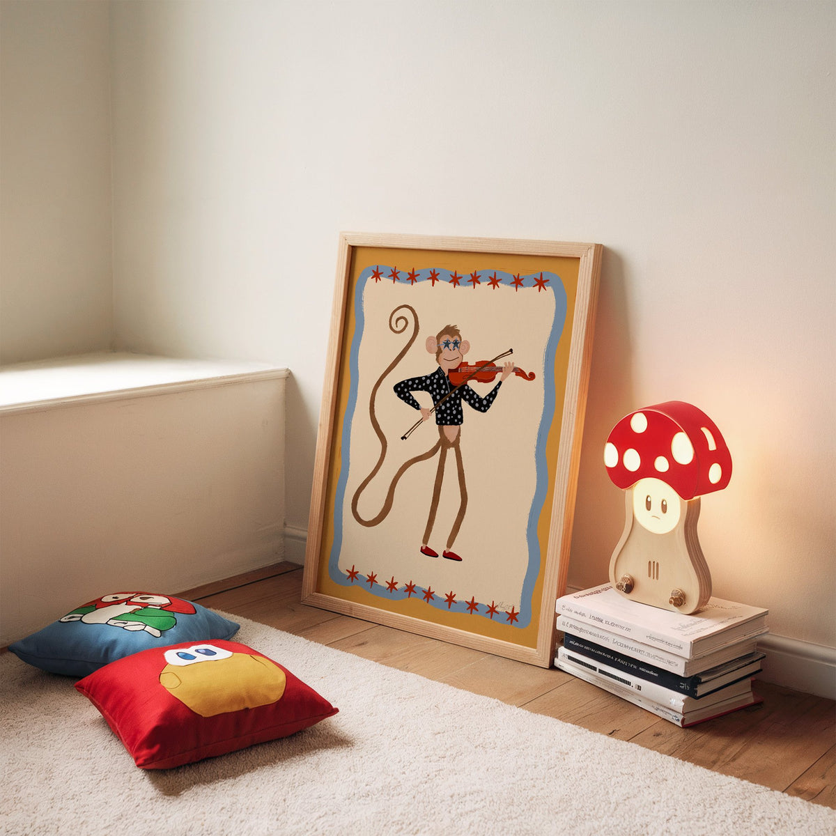 Monkey playing red violin nursery print in an oak frame leaning on a rug beside a mushroom lamp and floor cushions
