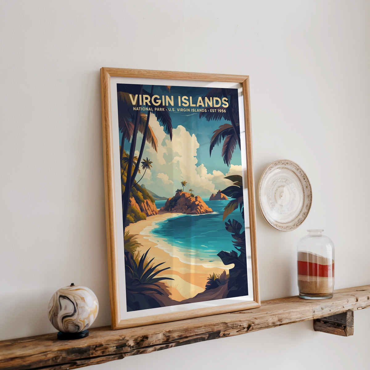 Virgin Islands National Park print in an oak frame on a wood shelf with ceramics and a sand-filled jar