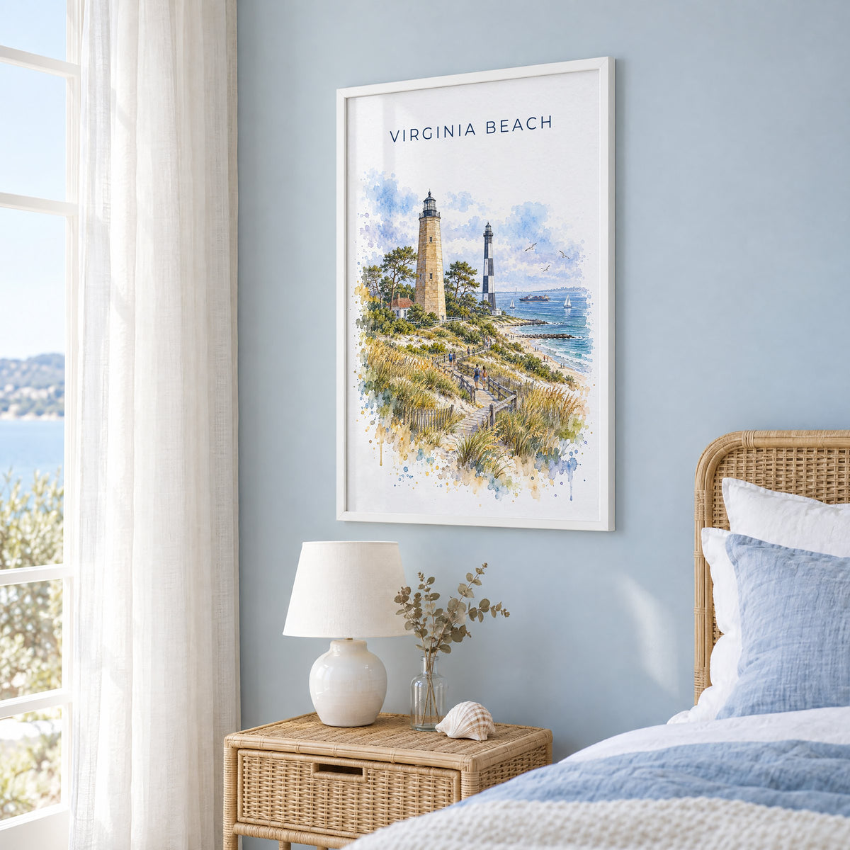 Virginia Beach watercolor print in a white frame on a pale blue wall beside a rattan bed in a coastal bedroom