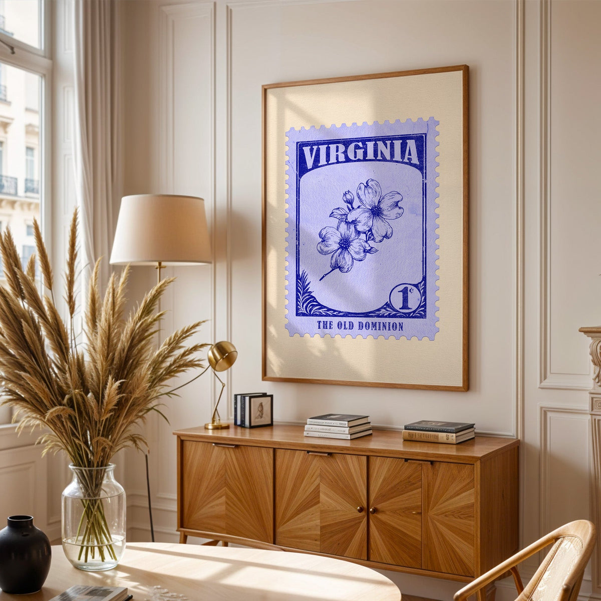 Virginia stamp print framed above a wooden sideboard, pampas grass in a glass vase and a floor lamp