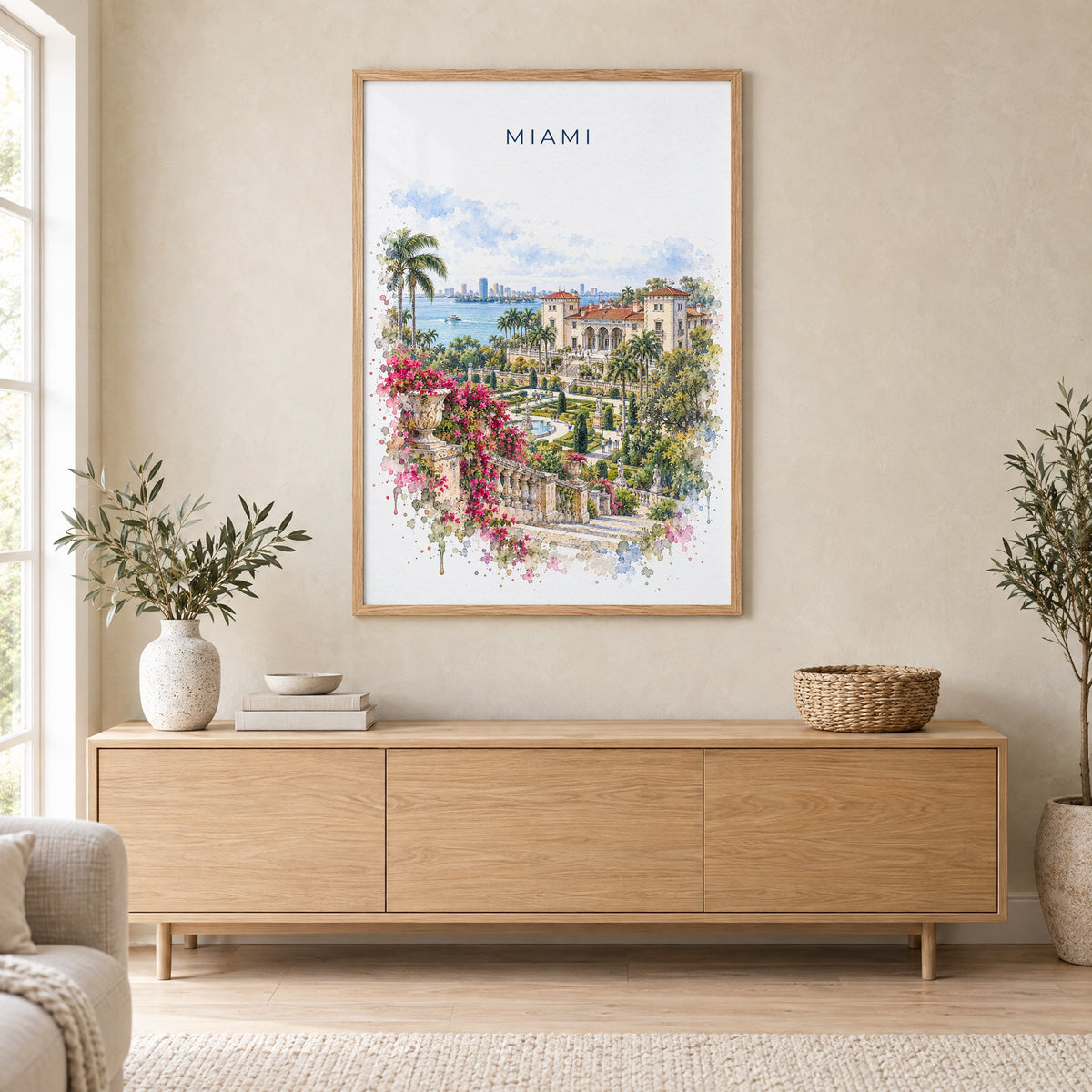 Vizcaya Miami watercolor print in an oak frame above a light wood sideboard in a Scandinavian living room