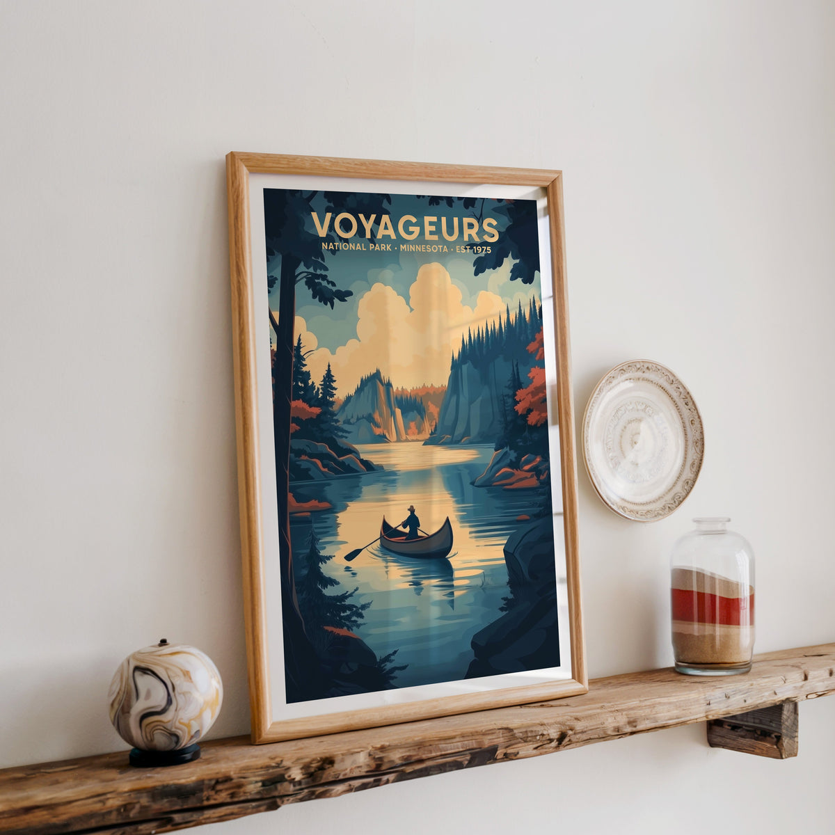 Voyageurs National Park print in an oak frame on a rustic wood shelf with ceramics and a sand-filled jar