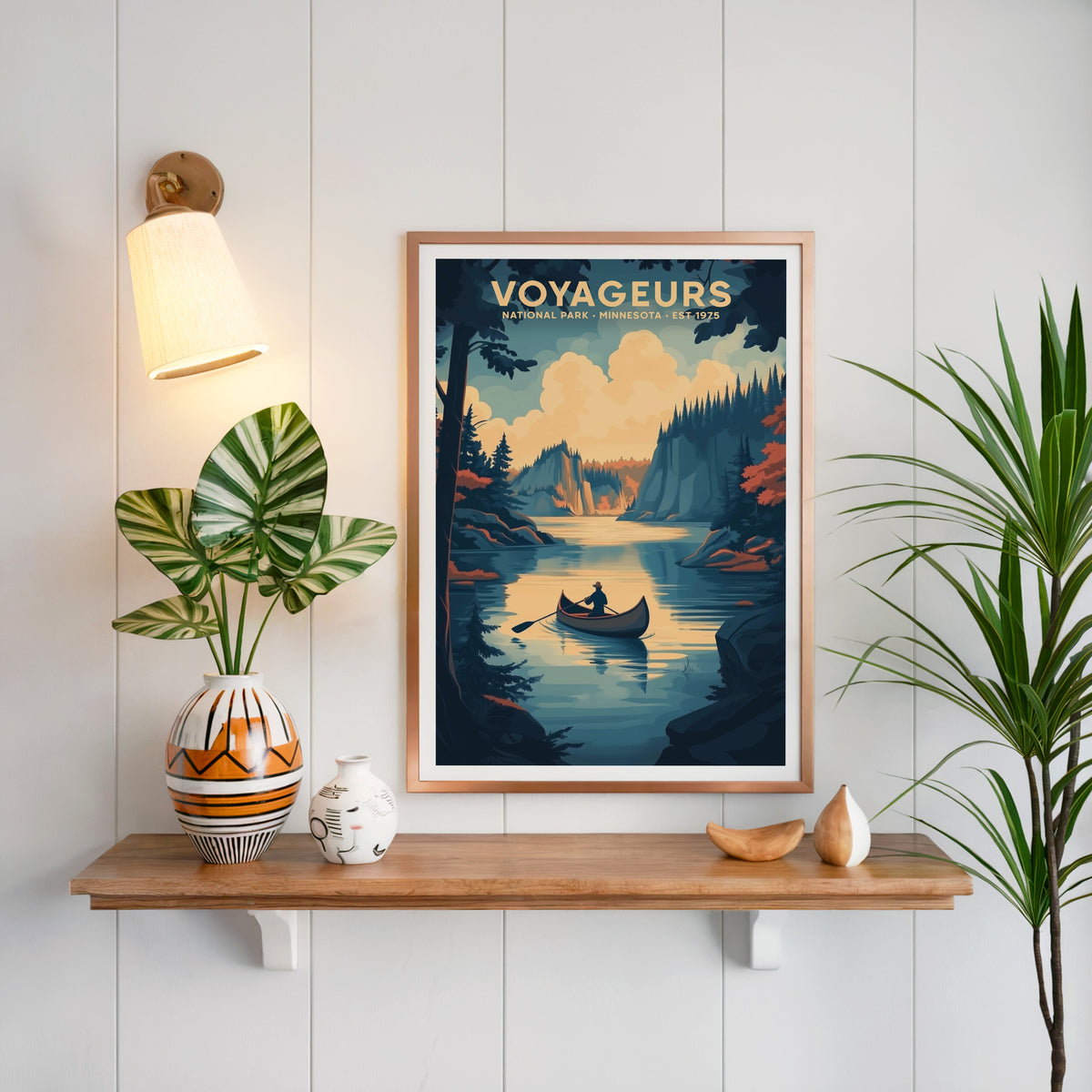 Voyageurs National Park print in a copper frame above an oak shelf on white shiplap with a brass sconce